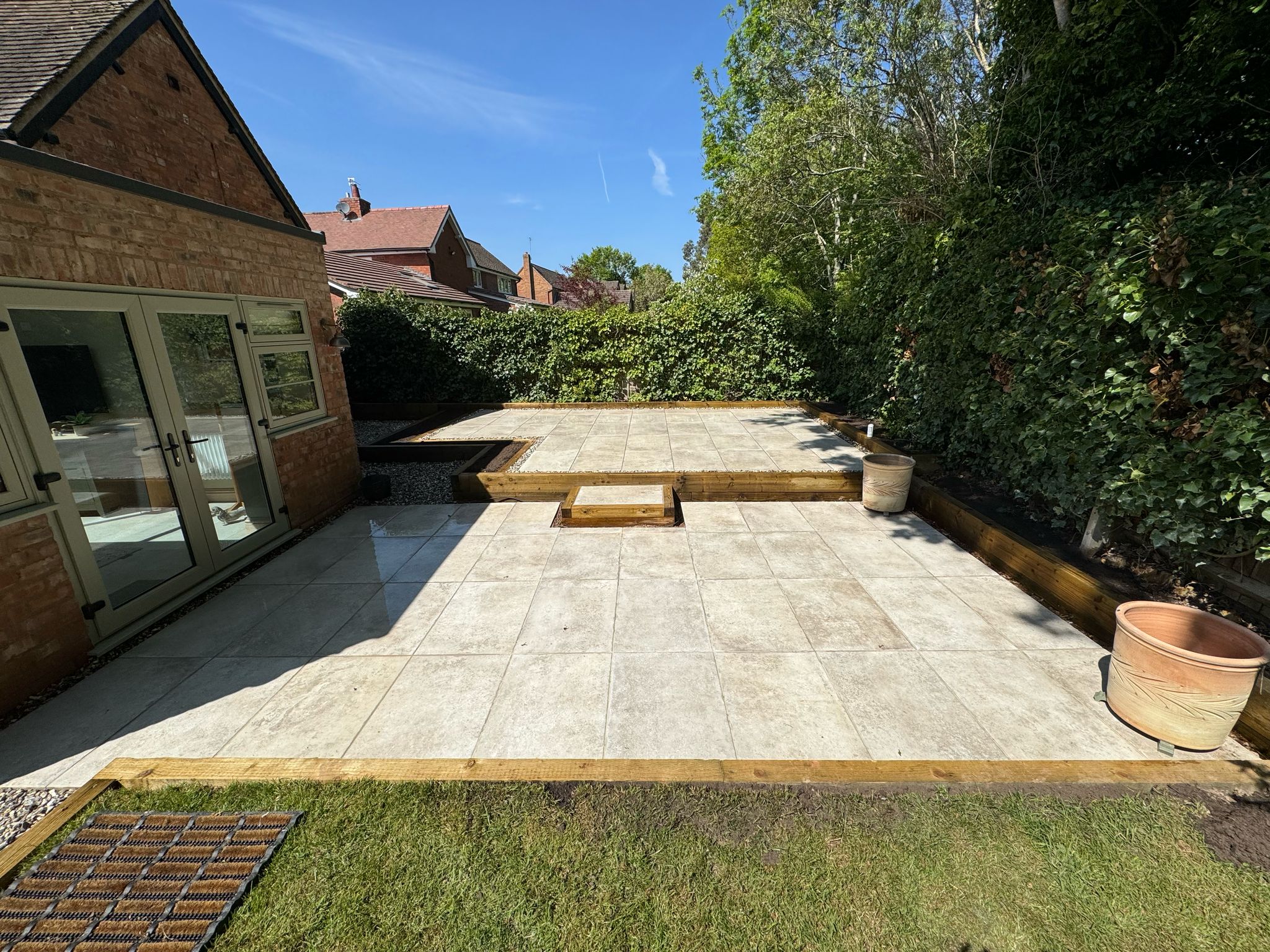 Porcelain patio, with sleepers, grass and stone